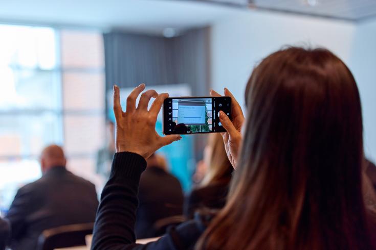 Woman taking photo during presentation